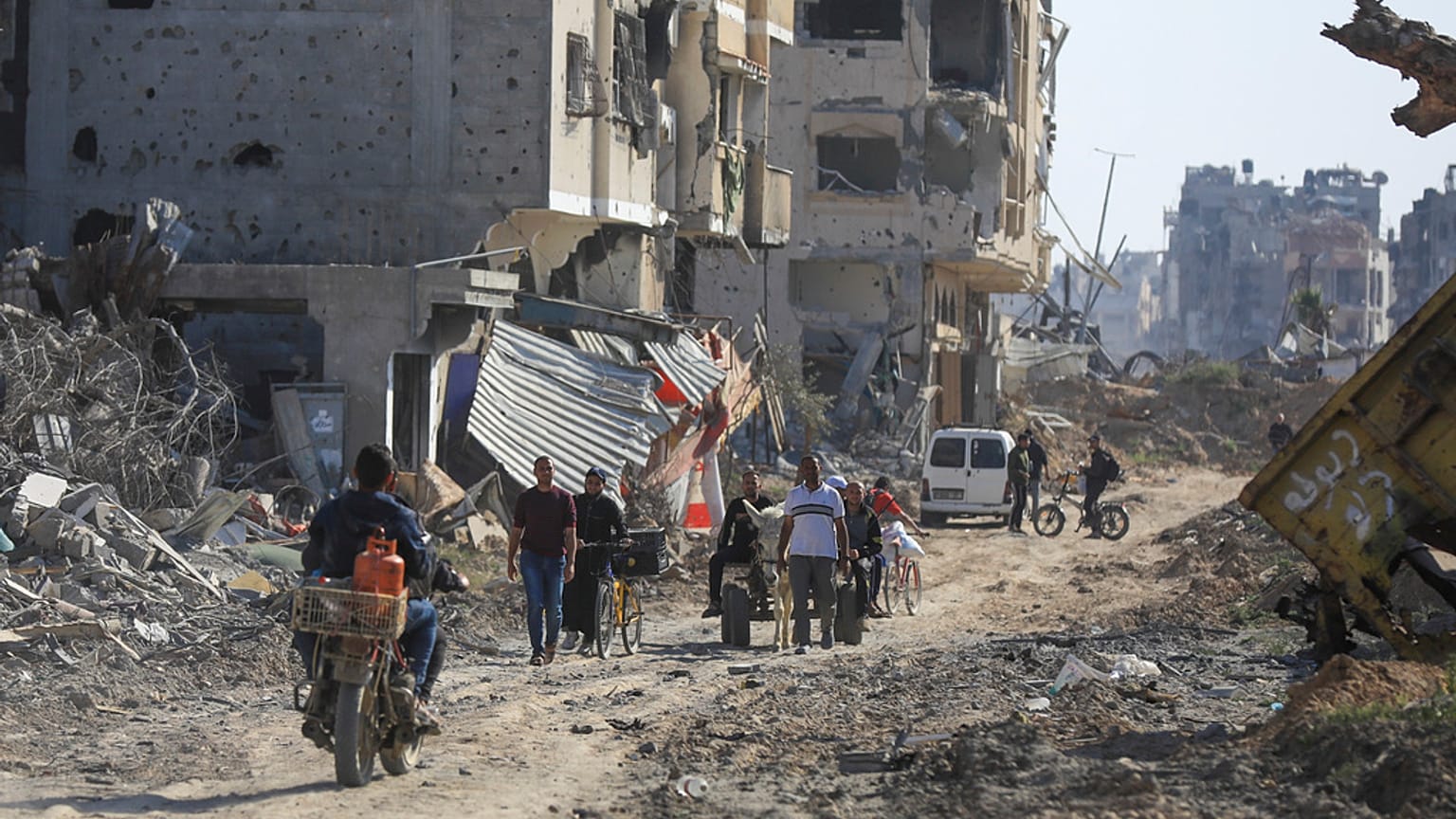 Des Palestiniens marchent à travers les destructions, après le retrait des troupes israéliennes de Khan Younès, dans le sud de la bande de Gaza, le dimanche 7 avril.