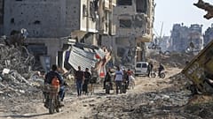 Des Palestiniens marchent à travers les destructions, après le retrait des troupes israéliennes de Khan Younès, dans le sud de la bande de Gaza, le dimanche 7 avril.