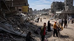 فلسطينيون يمشون وسط المباني المدمرة في خان يونس - غزة. 2024/04/08