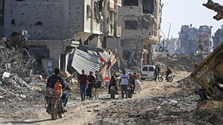Des Palestiniens marchent à travers les destructions, après le retrait des troupes israéliennes de Khan Younès, dans le sud de la bande de Gaza, le dimanche 7 avril.