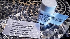 Sobre una mesa se ve un frasco de osimertinib (marca comercial: Tagrisso).