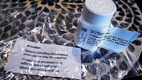 A prescription bottle named osimertinib (brand name: Tagrisso) is seen on a table.