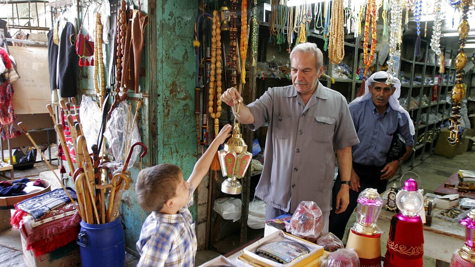 بائع فلسطيني يحمل لعبة مصابيح في  اليوم الأول من شهر رمضان المبارك في مدينة الخليل بالضفة الغربية