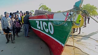 Captura de vídeo de Television Mozambique, que muestra a un grupo junto al barco que, según los medios locales, naufragó el domingo frente a la costa norte de Mozambique