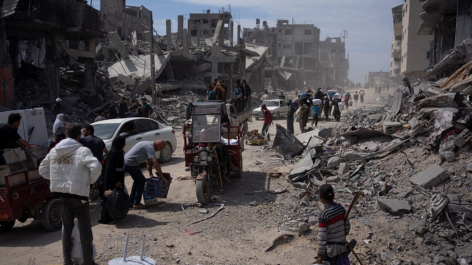 Un grupo de palestinos caminaba el martes entre la devastación causada por los ataques de Israel, que ha retirado tropas de la ciudad