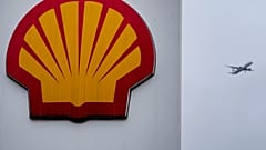 An aircraft passes a sign at a shell petrol station in London, Thursday, Feb. 2, 2023.
