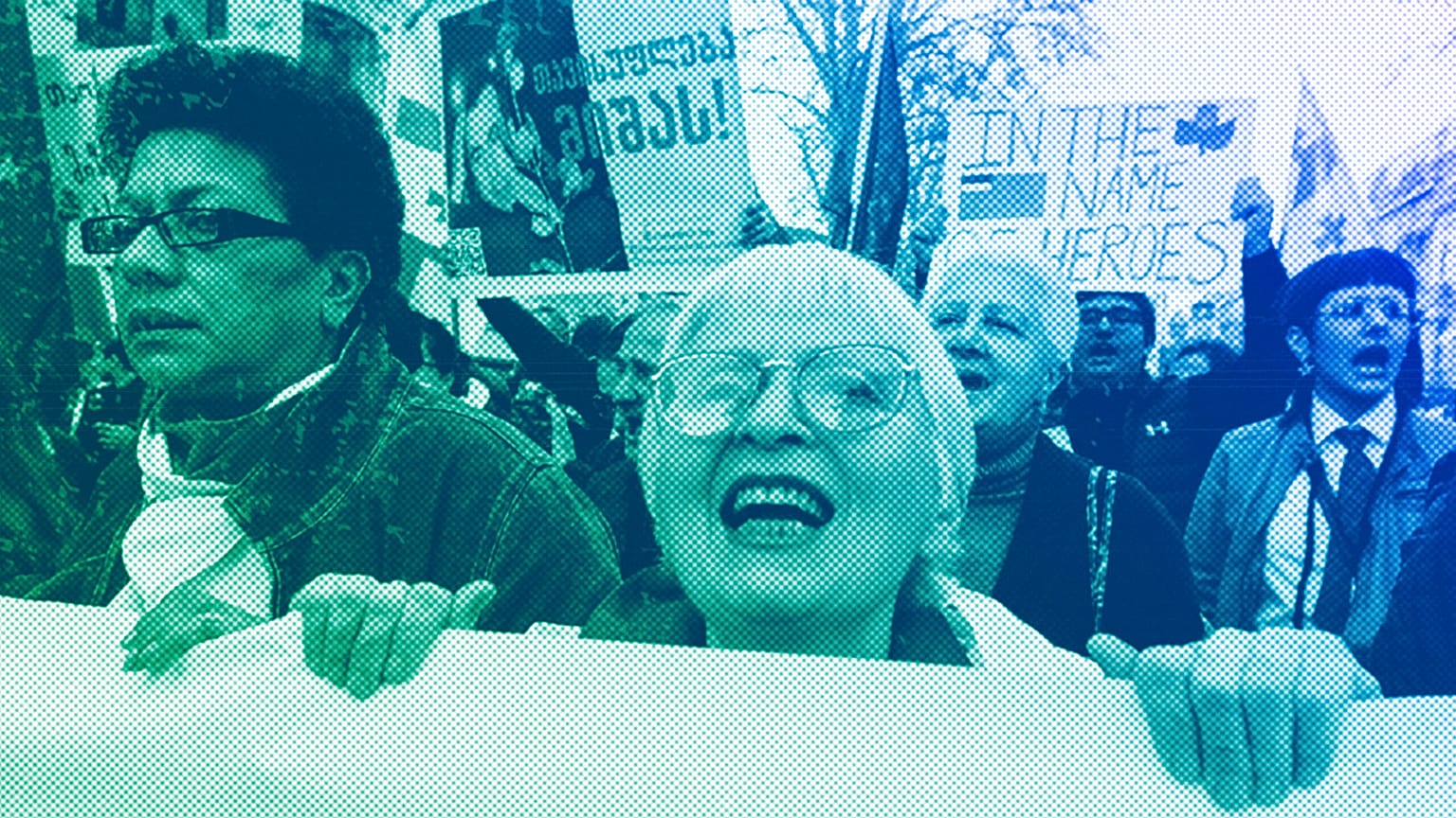 A woman shouts as other protestors march outside the parliament building in protest of "the Russian law" in Tbilisi, April 2024