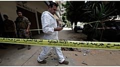 محقق من الجيش اللبناني يتفقد هاتفه المحمول خارج المبنى الذي اندلعت فيه الاشتباكات بين القوات اللبنانية وعضو سابق في تنظيم الدولة الإسلامية_ طرابلس