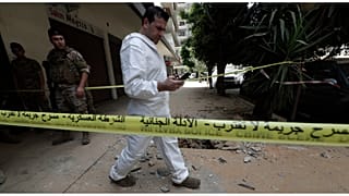 محقق من الجيش اللبناني يتفقد هاتفه المحمول خارج المبنى الذي اندلعت فيه الاشتباكات بين القوات اللبنانية وعضو سابق في تنظيم الدولة الإسلامية_ طرابلس