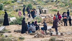 فلسطينيون في دير البلح يزورون في أول أيام عيد الفطر قبور أقاربهم الذين قتلتهم إسرائيل