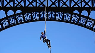 Anouk Garnier climbs up second floor of the Eiffel Tower by rope.