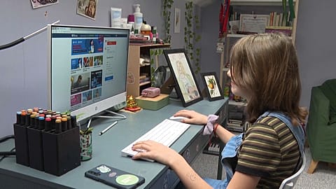 Polish fifth grader sitting at computer at home