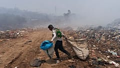 Un reciclador camina entre nubes de humo generadas por un incendio en un basurero en Villa Nueva, Guatemala, el martes 9 de abril de 2024.