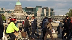 Pedestrians and cyclists pass each other at evening rush hour on O'Connell Bridge in central Dublin