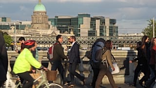 Pedestrians and cyclists pass each other at evening rush hour on O'Connell Bridge in central Dublin