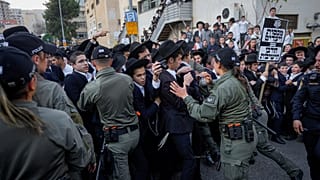 Israeli border police officers push back Ultra-Orthodox Jewish men during a protest against army recruitment in Jerusalem