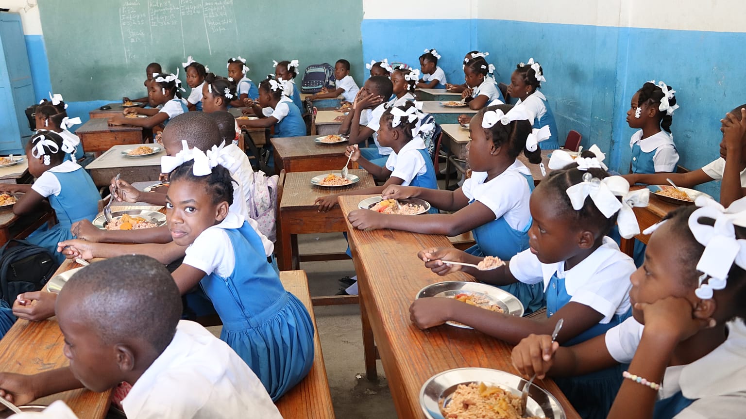 Niños recibiendo comida en la escuela en Puerto Príncipe