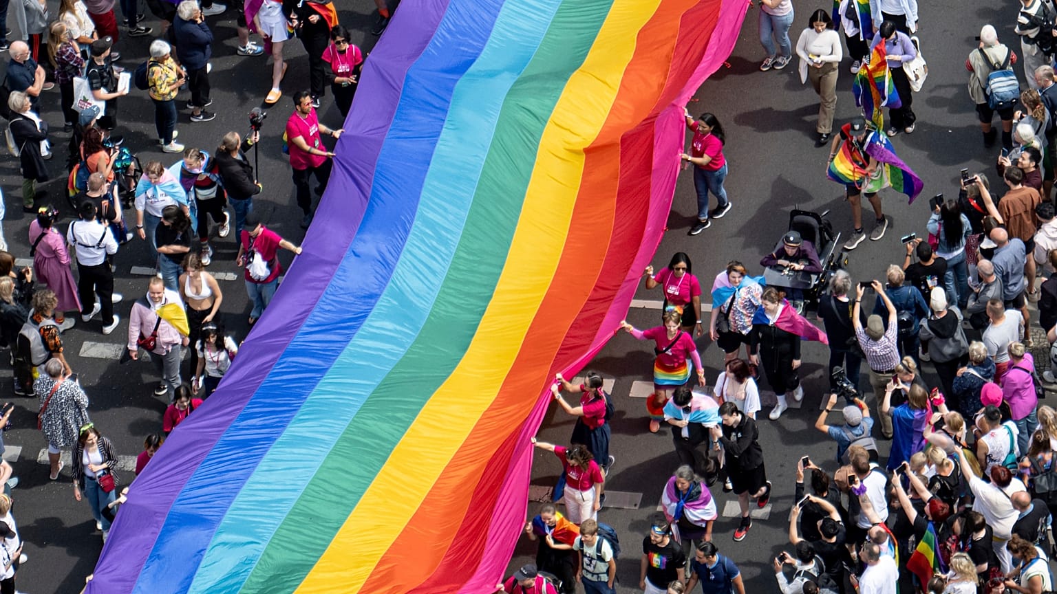 People hold a rainbow flag as they attend the 45th Berlin Pride Parade for Christopher Street Day (CSD) in Berlin, Germany.