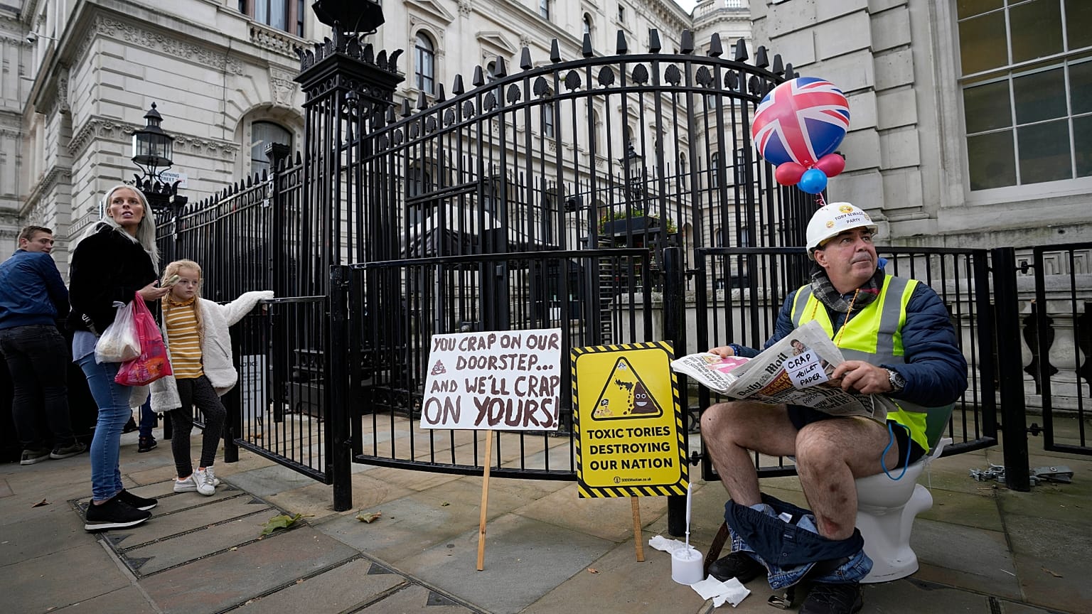 An activist sits on a toilet at the entrance to Downing Street to protest against raw sewage dumping in the rivers and seas around the UK.