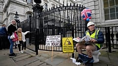 An activist sits on a toilet at the entrance to Downing Street to protest against raw sewage dumping in the rivers and seas around the UK.