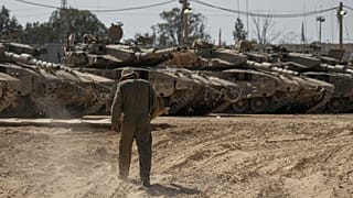Israeli soldiers work on tanks at a staging ground near the border with the Gaza Strip, in southern Israel, Thursday, April 11, 2024.