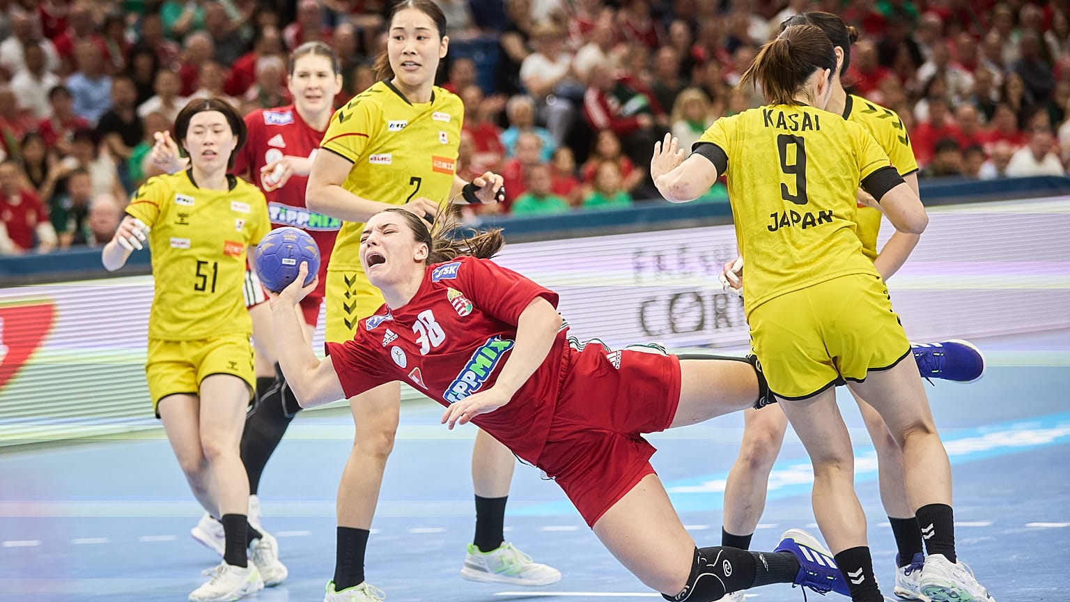 Vámos Petra (piros mezben) betörése japán játékosok között a Magyarország - Japán mérkőzésen a debreceni Főnix Arénában 2024. április 14-én.