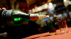Olcsó szeszes italt tölt poharakba egy nő egy prágai kocsmában 2012. szeptember 12-én