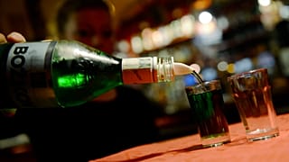 Olcsó szeszes italt tölt poharakba egy nő egy prágai kocsmában 2012. szeptember 12-én