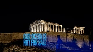 Greenpeace Greece activists project a message reading: 'Our Ocean Is Not For Sale' onto the Acropolis Hill.