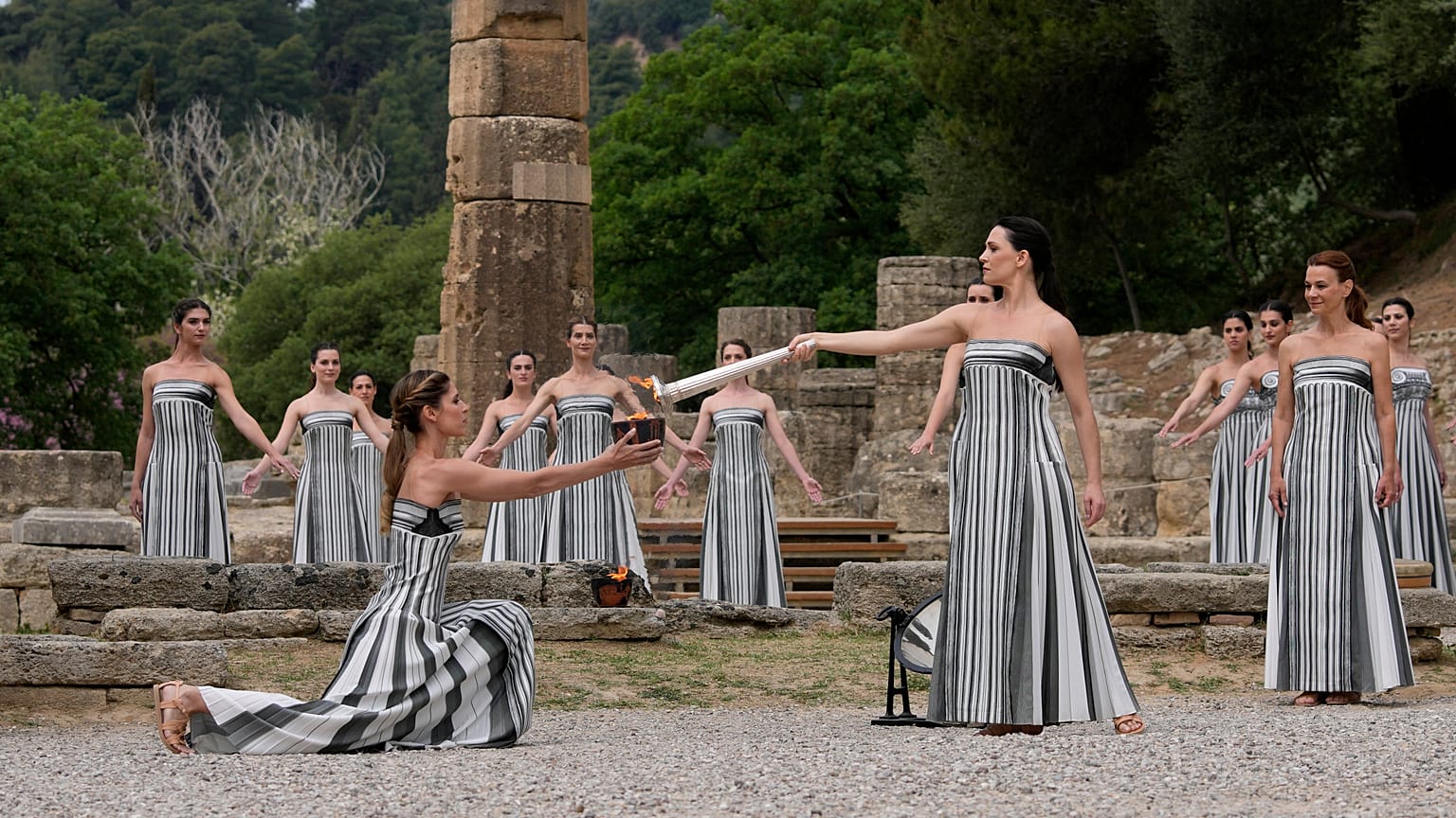 Actors light a torch at the official flame lighting for the Paris Olympics at the home of the ancient games in Greece.