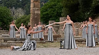 Actors light a torch at the official flame lighting for the Paris Olympics at the home of the ancient games in Greece.