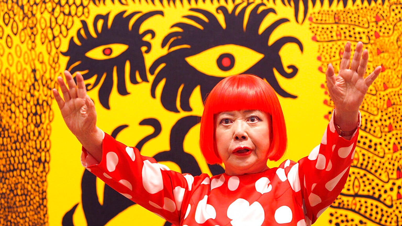 Japanese artist Yayoi Kusama poses for photographers at the 'Earth Carrying with it a Tale of the Cosmos' at the Tate Modern in London, 2012. 