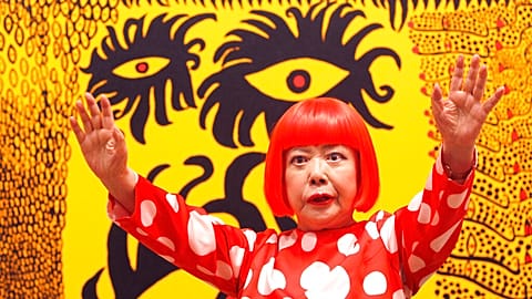 Japanese artist Yayoi Kusama poses for photographers at the 'Earth Carrying with it a Tale of the Cosmos' at the Tate Modern in London, 2012. 