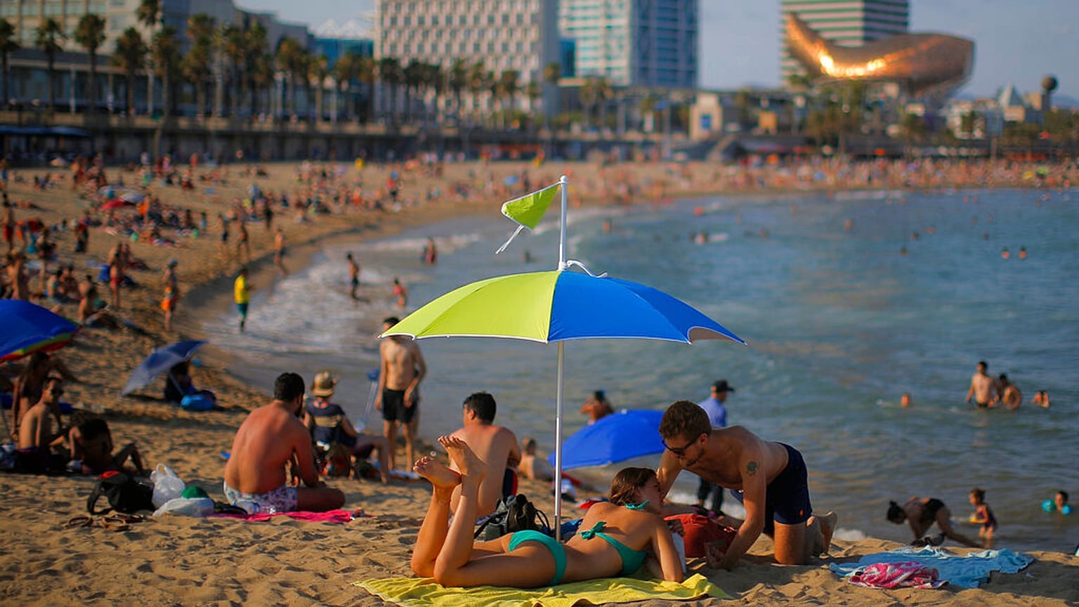 İspanya'nın Barselona kentindeki Barceloneta Plajı'nda güneşin tadını çıkaran vatandaşlar