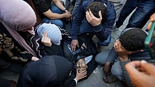  Palesztinok gyászolnak a Deir al Balah-i Al Aqsa kórházban egy izraeli bombázást követően a Gázai övezet középső részén lévő Maghazi menekülttáborban