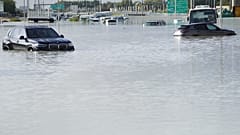 In Dubai ließen Menschen in Autos  ihre überschwemmten Fahrzeuge zurück und gingen zu Fuß weiter.