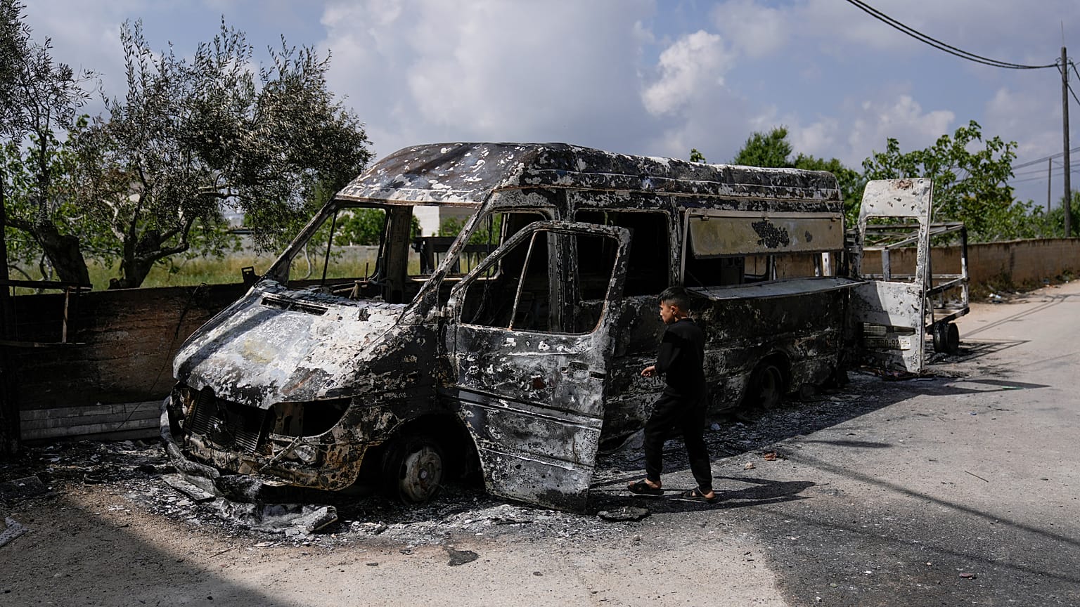 فتى فلسطيني ينظر إلى السيارات التي أحرقها المستوطنون في قرية قصرة بالقرب من مدينة نابلس بالضفة الغربية المحتلة، الأحد 14 أبريل 2024