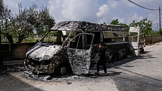 فتى فلسطيني ينظر إلى السيارات التي أحرقها المستوطنون في قرية قصرة بالقرب من مدينة نابلس بالضفة الغربية المحتلة، الأحد 14 أبريل 2024