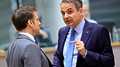 Emmanuel Macron francia elnök (balra) és Kiriakosz Micótakisz görög miniszterelnök tárgyal a brüsszeli EU-csúcs kezdete előtt
