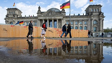 Passers-by walk past the Reichstag building in Berlin Friday, April 5, 2024. 