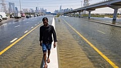 Un hombre camina a lo largo de una barrera entre las inundaciones causadas por las fuertes lluvias en Dubái, Emiratos Árabes Unidos, el 18 de abril de 2024.
