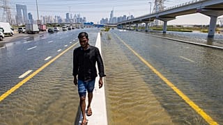 Un hombre camina a lo largo de una barrera entre las inundaciones causadas por las fuertes lluvias en Dubái, Emiratos Árabes Unidos, el 18 de abril de 2024.
