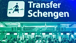 Passengers arriving at the Henri Coanda International Airport pass under a Schengen Information sign, in Otopeni, near Bucharest, March 2024