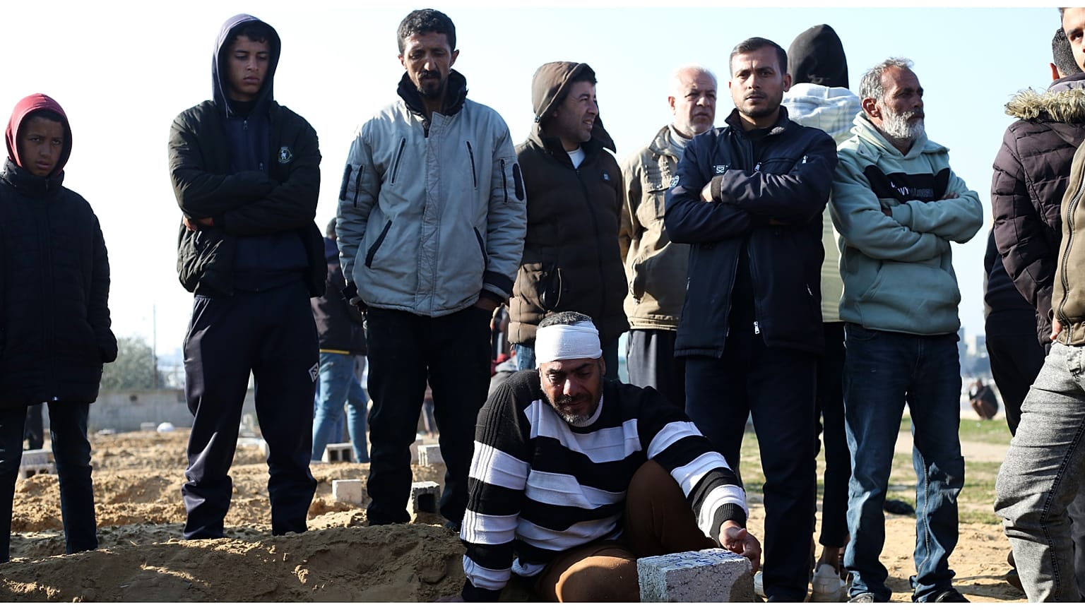 فلسطينيون يقفون حول قبر قريب لهم قُتل في القصف الإسرائيلي لقطاع غزة في خان يونس يوم الاثنين 26 فبراير 2024.
