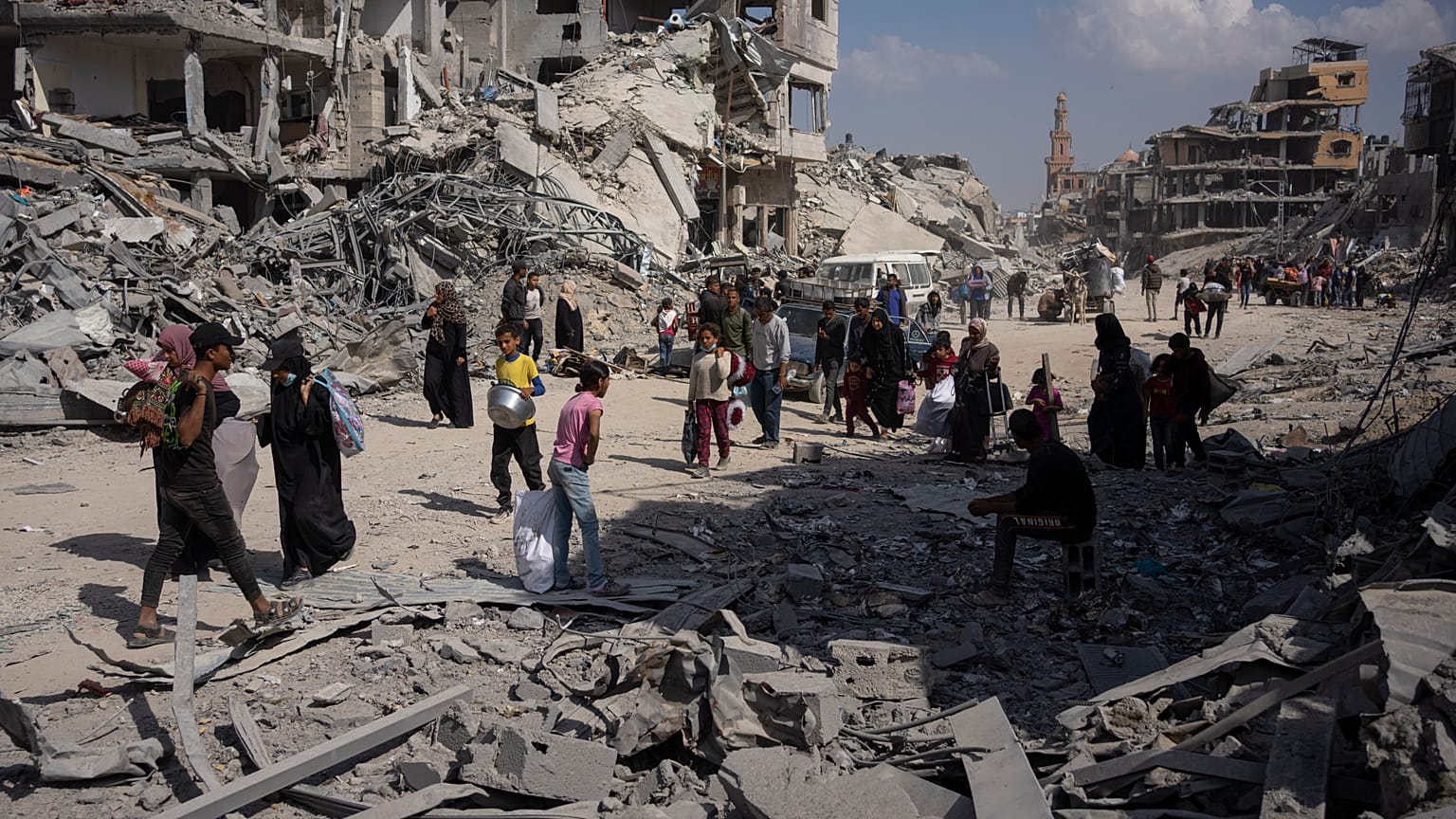 I palestinesi camminano tra le distruzioni a seguito dell'offensiva aerea e di terra israeliana a Khan Younis, nel sud della Striscia di Gaza, l'8 aprile 2024.