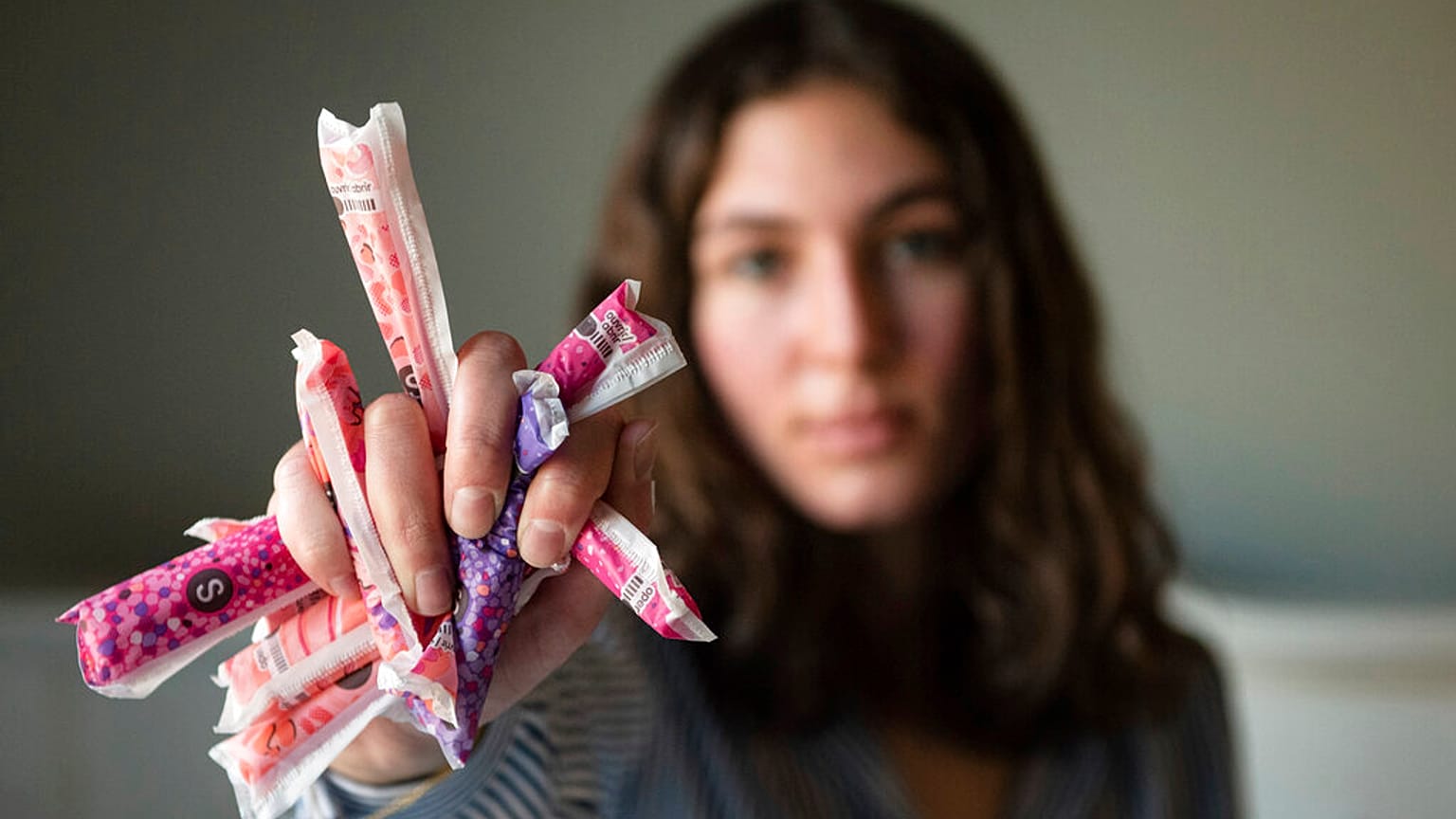 Une femme tient des produits menstruels