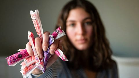 Sarina Horner, a 17-year-old senior at Forsyth Country Day School, holds a fistful of tampons as she sits for a portrait on her bed on Monday, Feb. 14, 2022, in Lewisville NC.