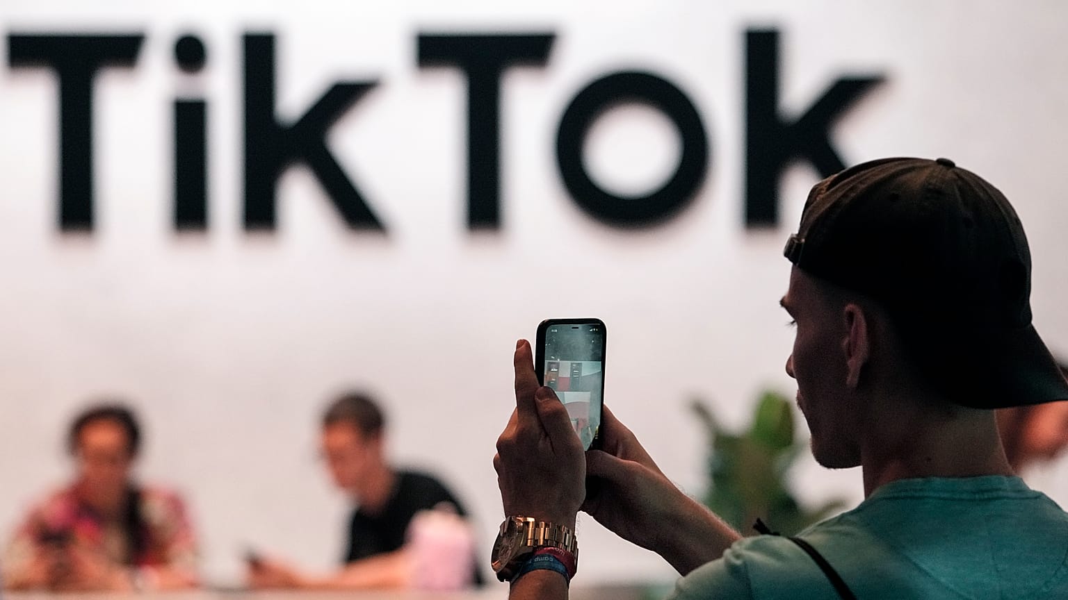 A visitor makes a photo at the TikTok exhibition stands at the Gamescom computer gaming fair in Cologne.