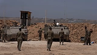 Израильские солдаты стоят рядом с бронетранспортерами на границе Израиля и сектора Газа 