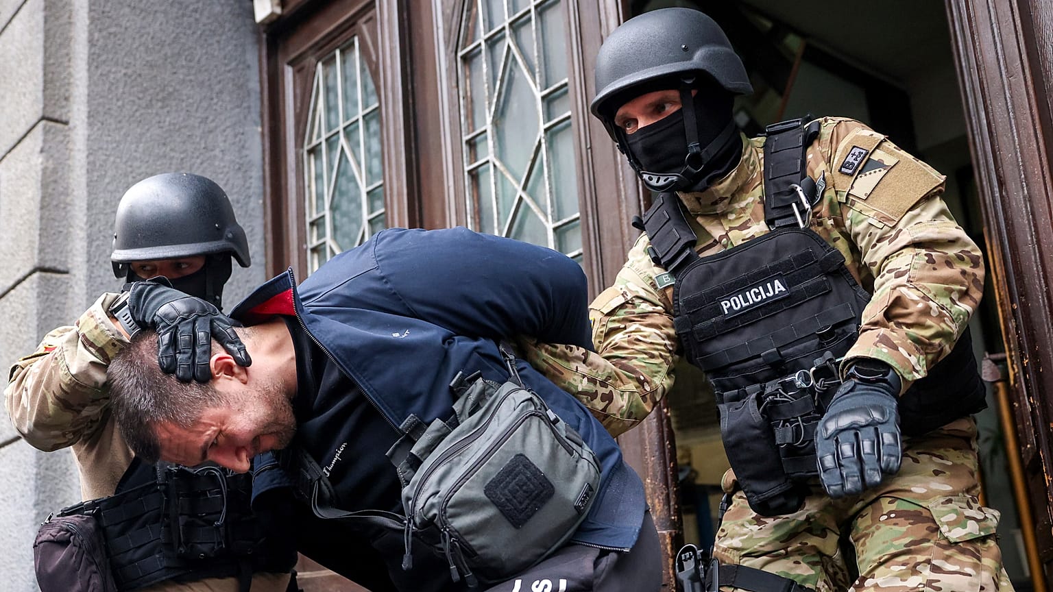 Members of the special police unit of Canton Sarajevo escort a person arrested in an operation codenamed "Black Tie" in Sarajevo, Bosnia, Monday, April 22, 2024